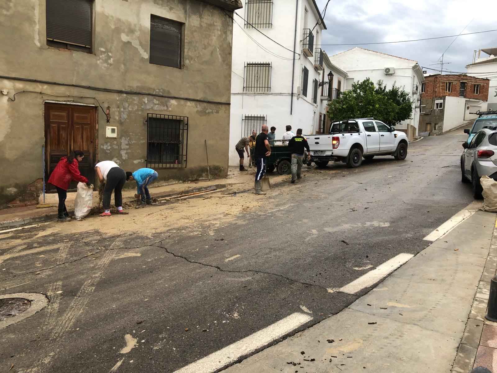 Vecinos de Fuente Tójar retiran el barro de la calle tras las riadas del fin de semana.