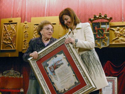 Luisa Zurita recibe de Encarnación Ortiz el título que la acredita como Hija Predilecta de Priego. (Foto: R. Cobo)